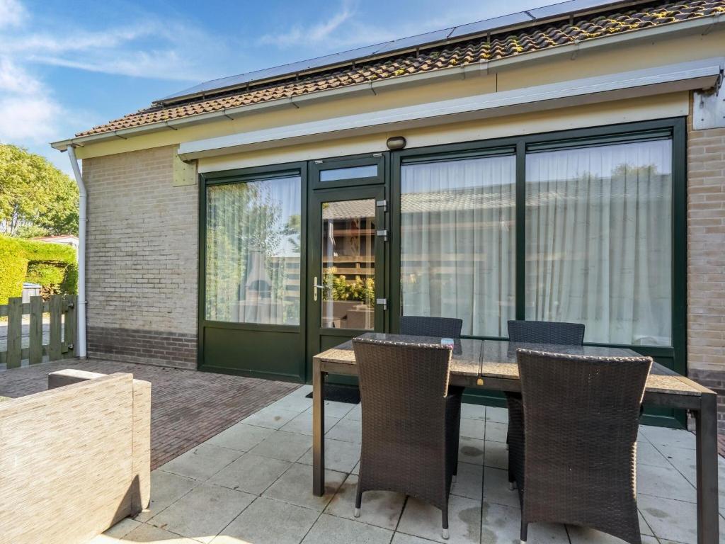 een patio met een houten tafel en stoelen bij Inviting holiday home in Baarland with terrace in Baarland