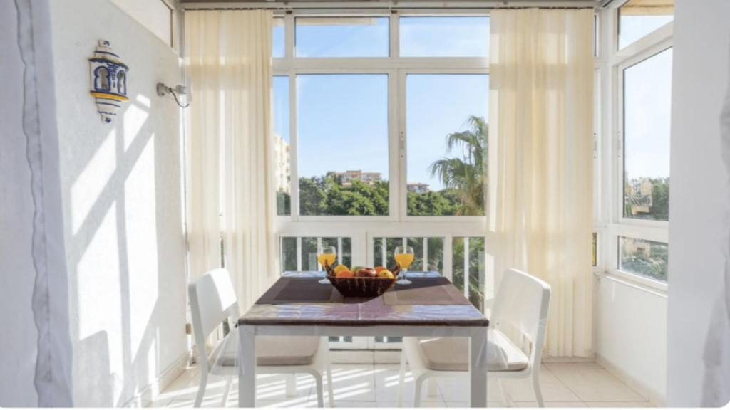 jadalnia ze stołem i dużym oknem w obiekcie 797 Holiday Rentals- Luminoso estudio en Arroyo de la Miel w mieście Benalmádena
