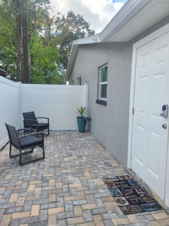 a patio with two chairs and a white fence at Diamond 4 in Tampa