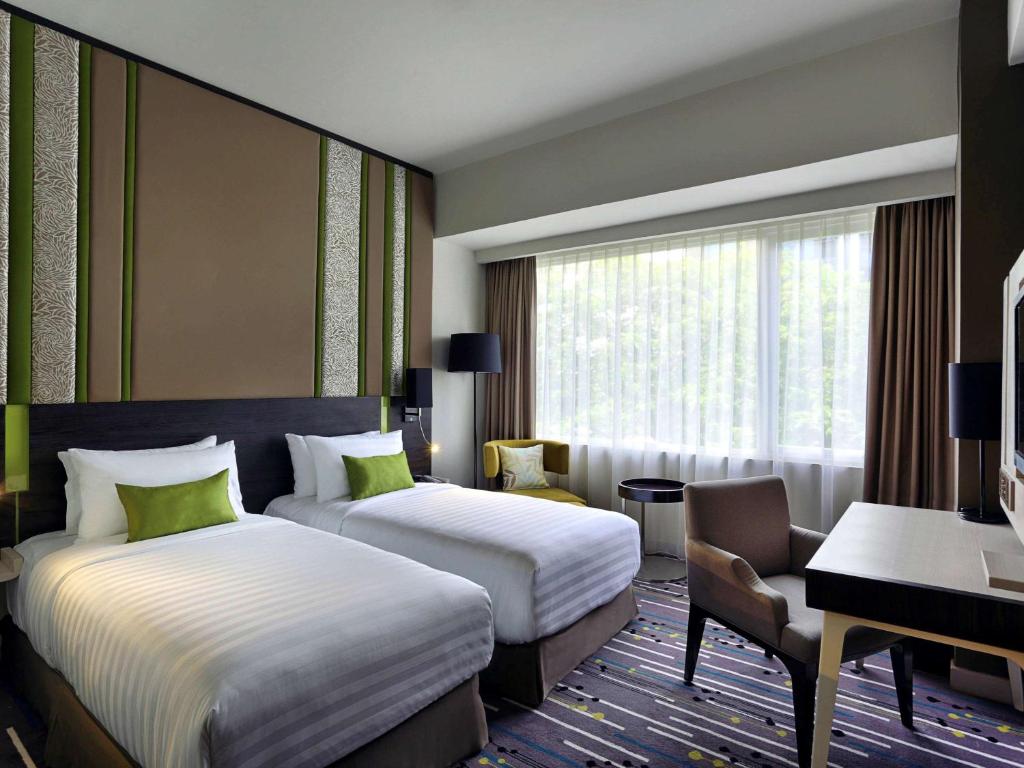 A bed or beds in a room at Mercure Serpong Alam Sutera