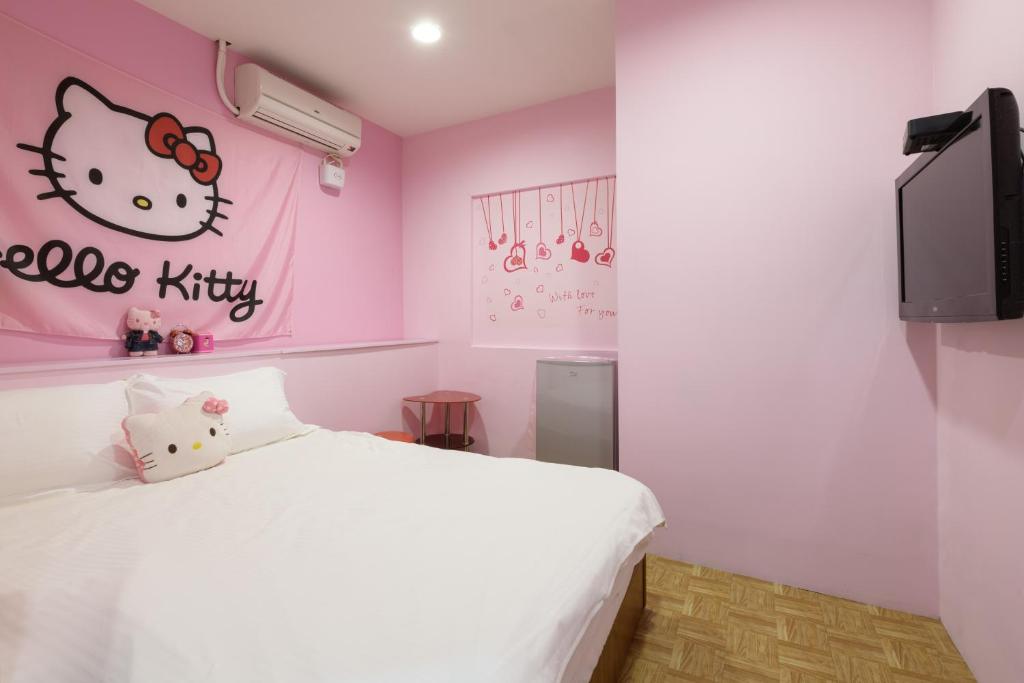 a bedroom with a white bed and a hello kitty wall at 羅東小宅一生 in Luodong
