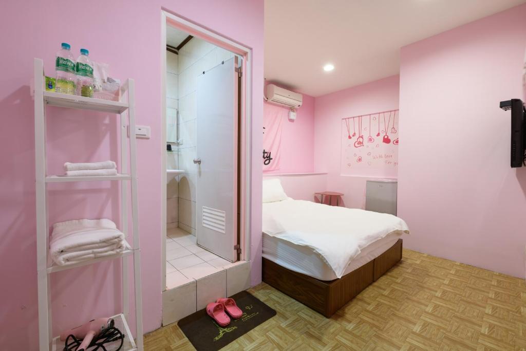 a pink bedroom with a bed and a walk in shower at 羅東小宅一生 in Luodong