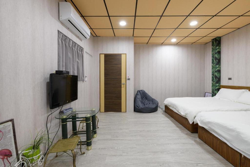 a bedroom with a bed and a tv and a table at 羅東小宅一生 in Luodong