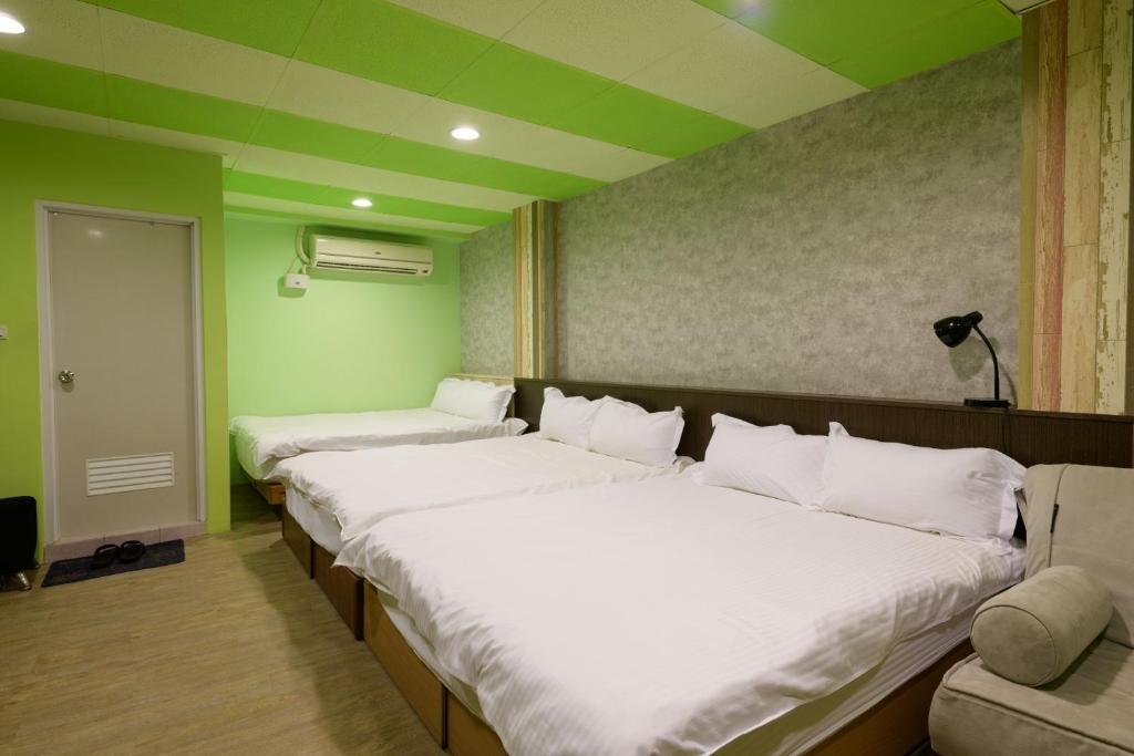 a row of beds in a room with green walls at 羅東小宅一生 in Luodong