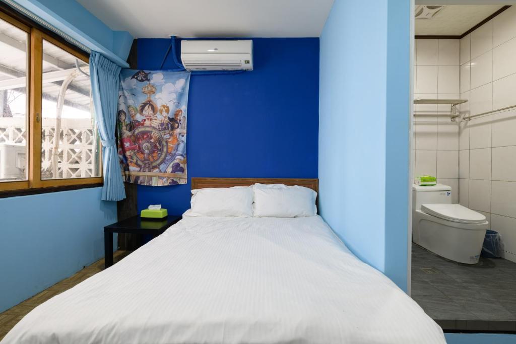 a blue room with a bed and a toilet at 羅東小宅一生 in Luodong
