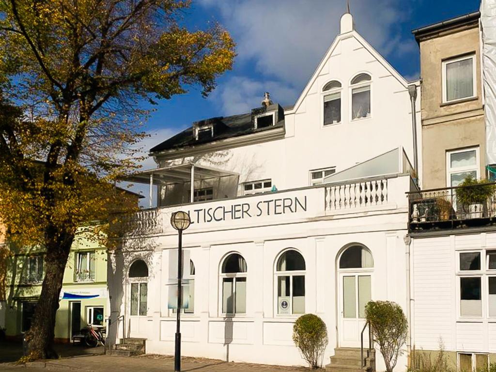 a white building with a sign that reads tisser system at Baltischer Sternenblick in Rostock