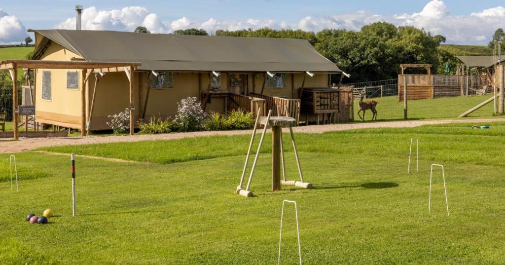 un parque infantil en un campo junto a una casa en Luxury Safari Lodge surrounded by deer!! 'Roe', en Crediton