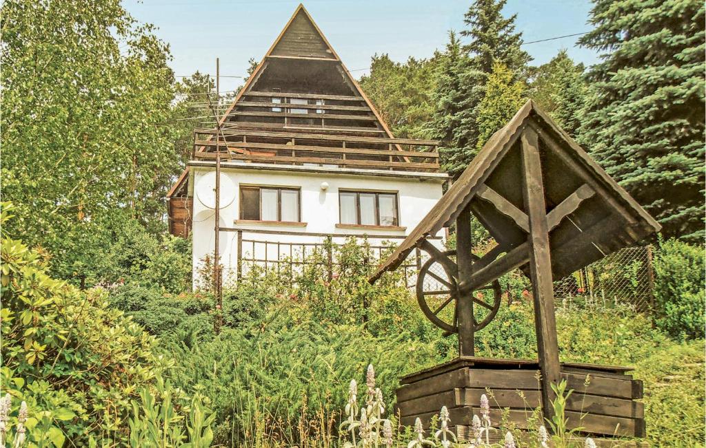 a house in the middle of a field with a wooden structure at Gorgeous Home In Mucharz With Sauna in Mucharz