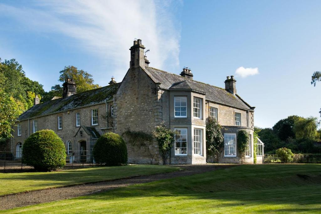 an old stone house on a grass field at Honeystone House in Hexham