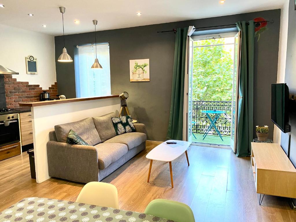 a living room with a couch and a table at Appartement au cœur de breil sur roya in Breil-sur-Roya