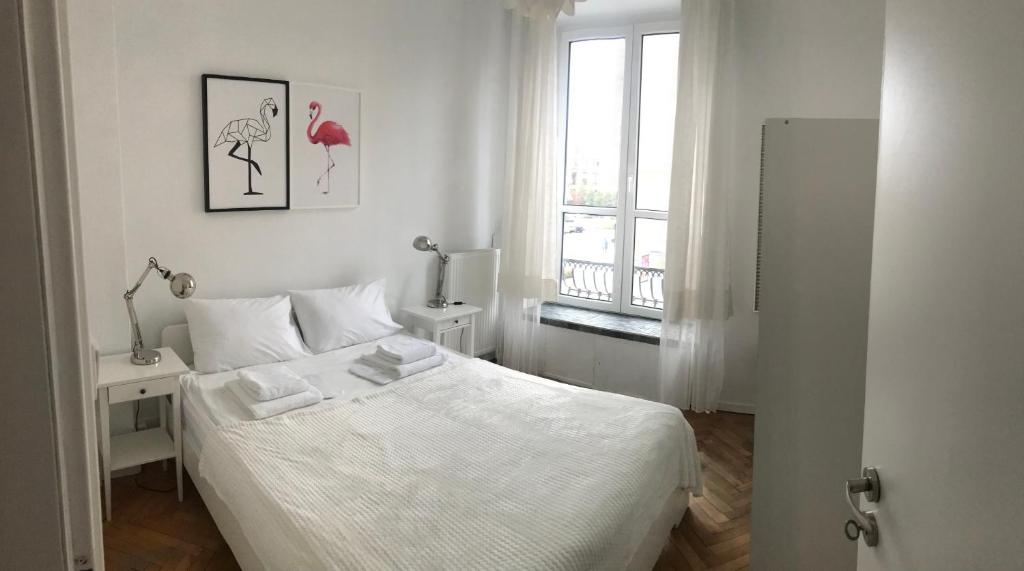 um quarto branco com uma cama e uma janela em Apartament Warecka em Varsóvia