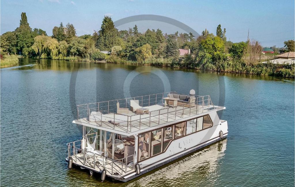 a white boat floating on a river at Cozy Ship In Havelsee With Kitchen in Milow