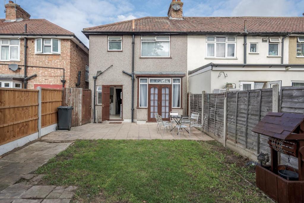 un patio trasero de una casa con una valla en Lovely 4-BedRoom House Near Romford Station en Romford