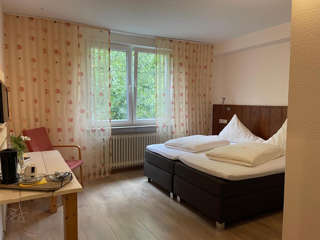 Schlafzimmer mit einem Bett, einem Schreibtisch und einem Fenster in der Unterkunft Haus Sommerhof in Sindelfingen