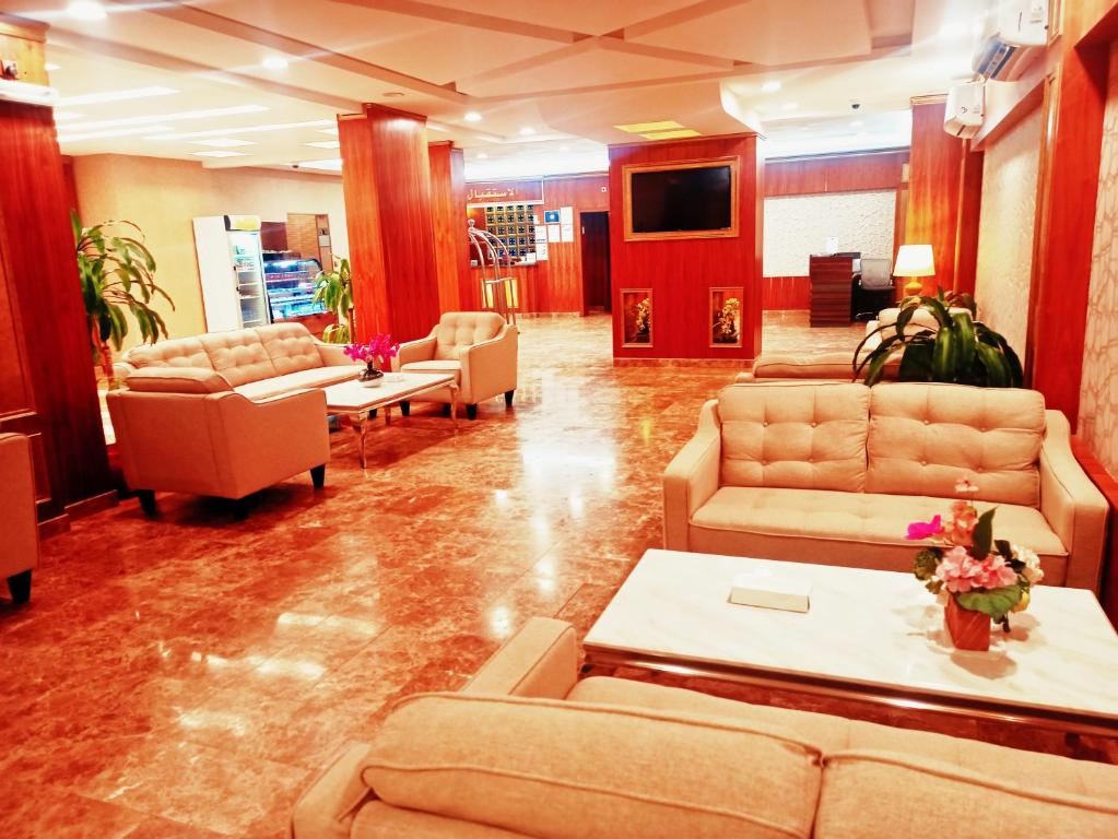 En el vestíbulo hay una sala de estar con sofás y mesas. en Taraf Yanbu 2, en Yanbu