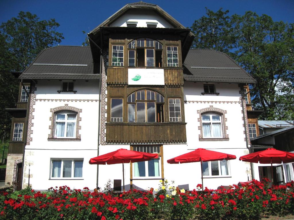 a building with red umbrellas in front of it at Zielone Wzgórze in Karpacz