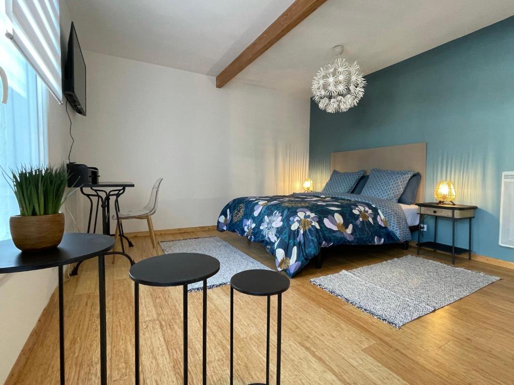 a bedroom with a bed and two tables and two chairs at Maison de Ville Lumineuse centre ville à pieds - Lit 160 in Quimper