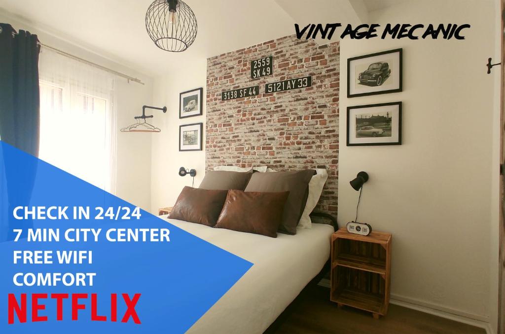 sypialnia z łóżkiem i ścianą z cegły w obiekcie Nouveau* Vintage Mecanic* Wifi*Netflix*Confort w mieście Venette