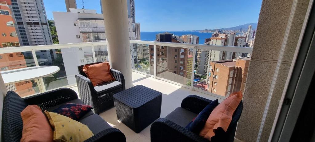 a balcony with couches and chairs and a view of a city at VISTAMAR 33 in Benidorm