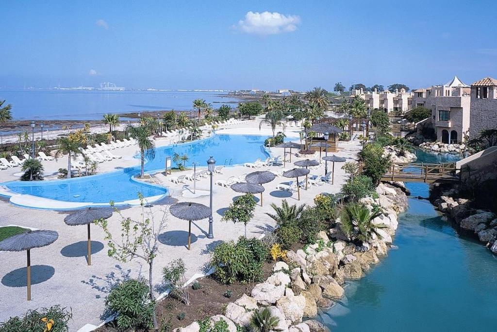 an aerial view of a resort with two pools and umbrellas at Moderno apartamento en Bahia Sur in San Fernando