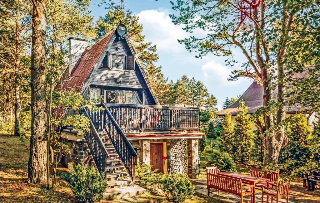 a cabin in the woods with a deck and a bench at Amazing Home In Stezyca With Kitchen in Stężyca