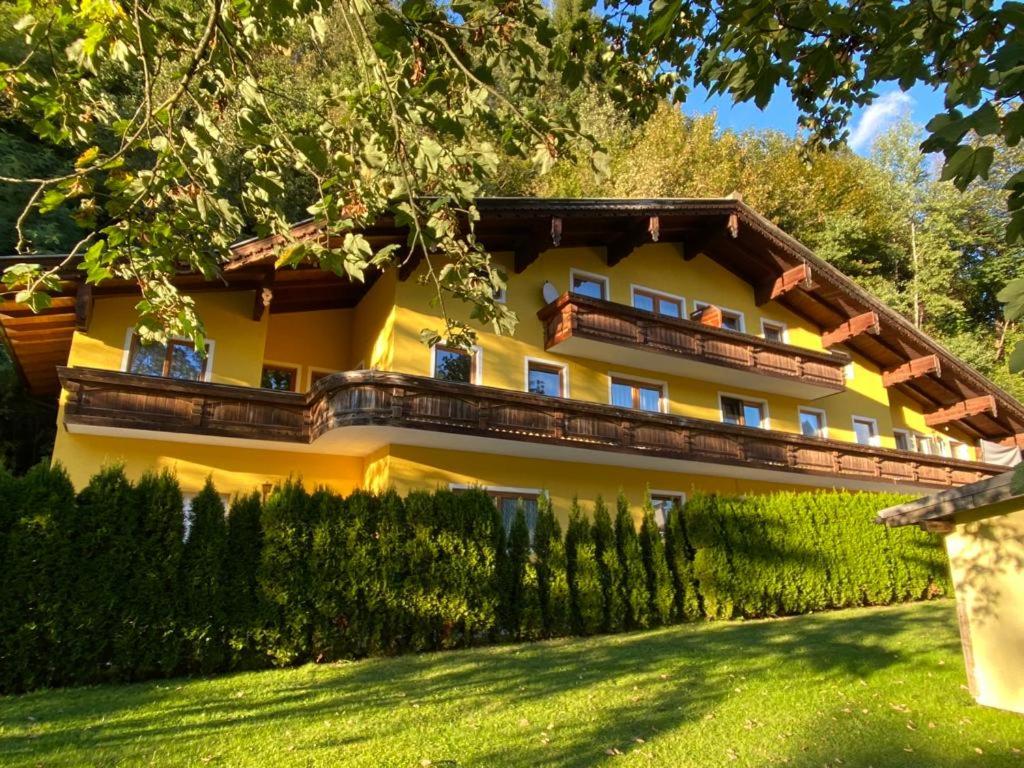 a yellow house with a fence in front of it at Appart Burgwies ink Nationalpark Sommercard in Stuhlfelden