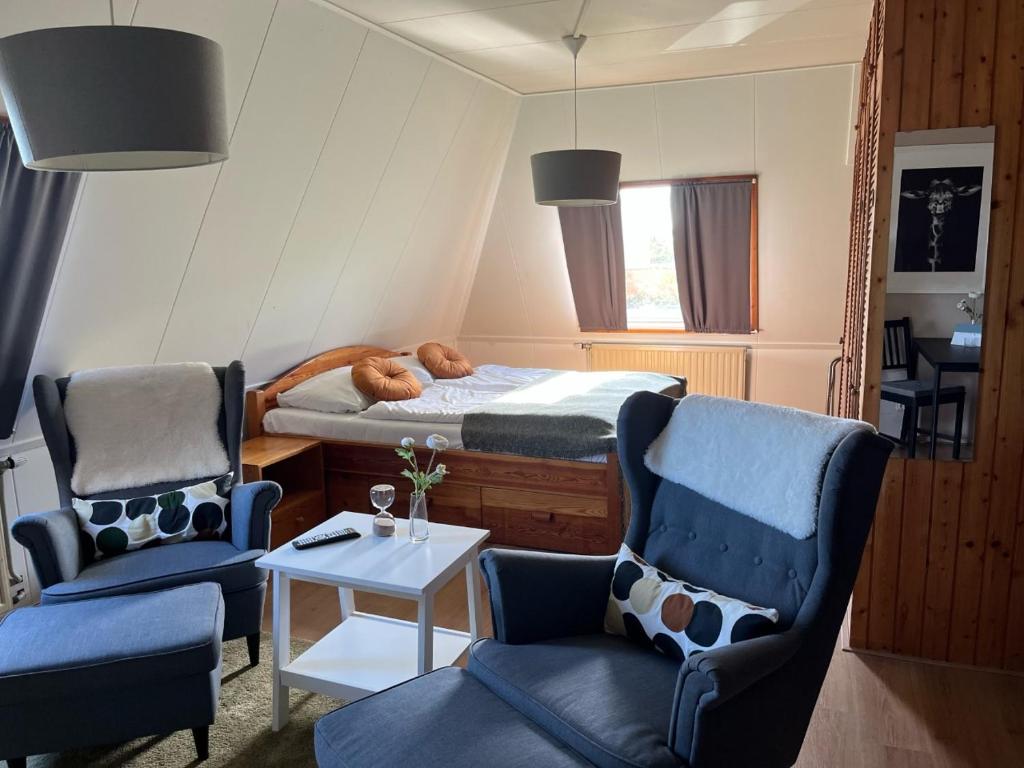 a bedroom with a bed and two chairs and a table at Hotel De Oude Molen in Groesbeek