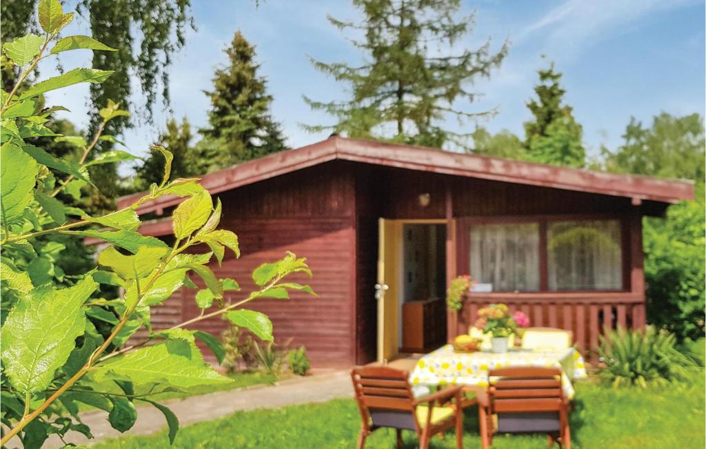 a small cabin with a table and chairs in front of it at Holiday Home Morag Kretowiny V in Pojezierce