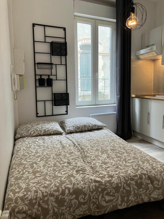 een slaapkamer met een bed en een groot raam bij Studio à deux pas des étangs in Peyriac-de-Mer