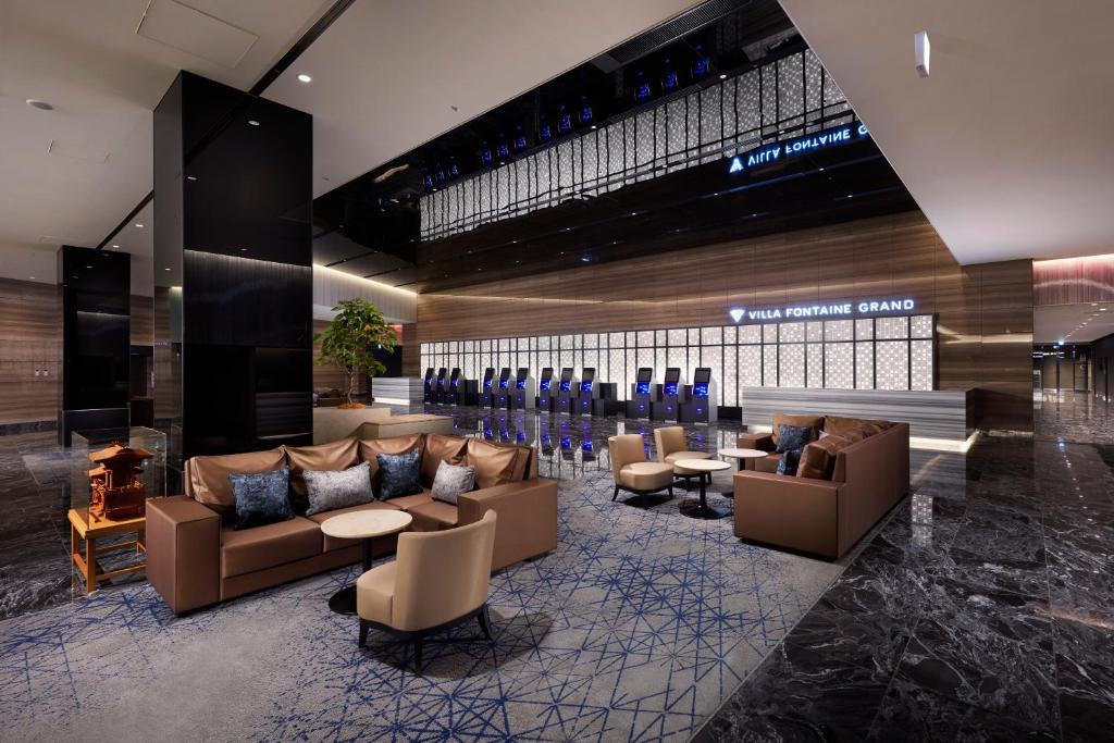 a lobby with couches and tables in a building at Villa Fontaine Grand Haneda Airport in Tokyo