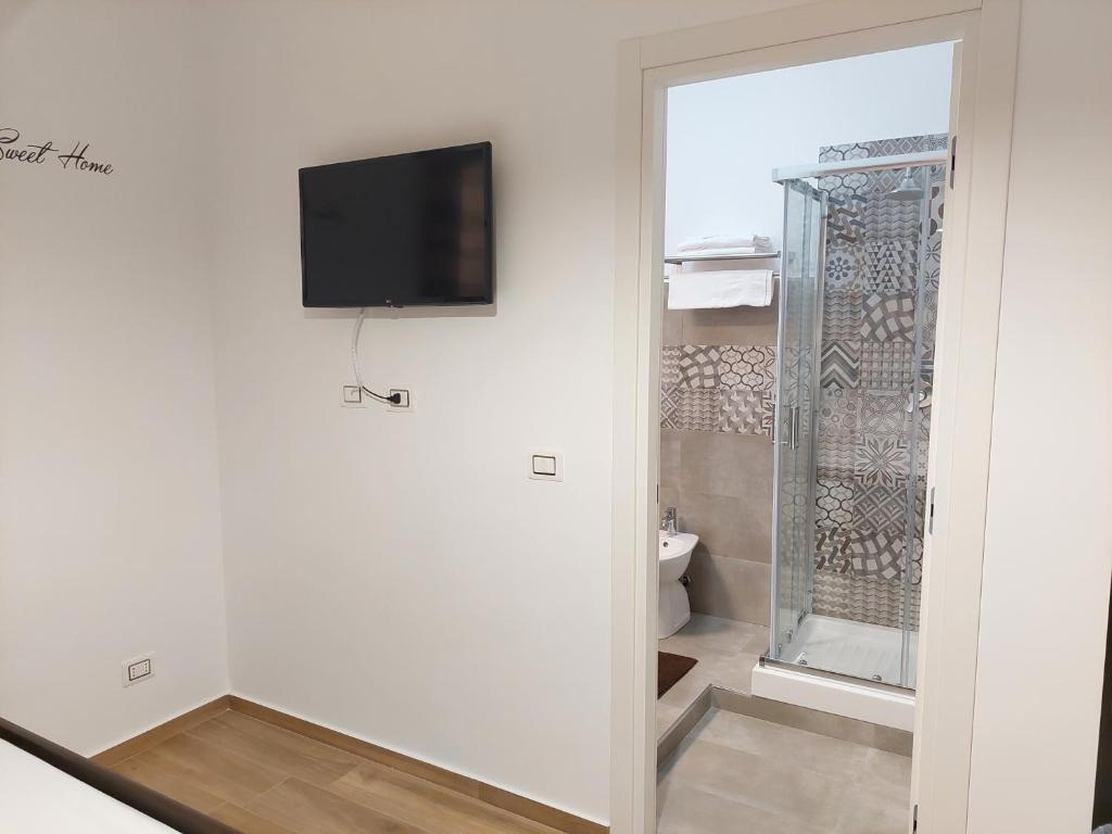 łazienka z toaletą i telewizorem na ścianie w obiekcie Sunset House w mieście Balestrate