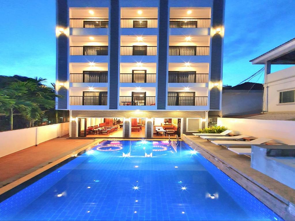 a hotel with a swimming pool in front of a building at Long Night Siem Reap Hotel in Siem Reap