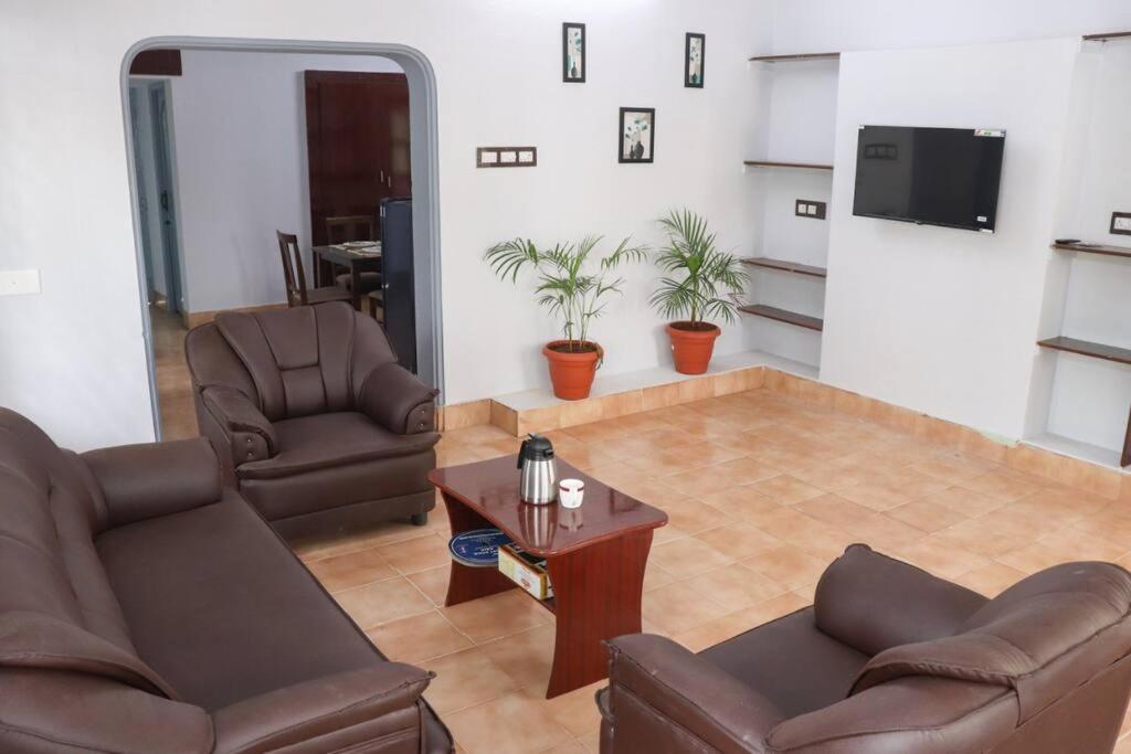 sala de estar con 2 sillas y mesa en Madura Homestay - Gorgeous Home with 2BHK 5 minutes from NH44, en Madurai