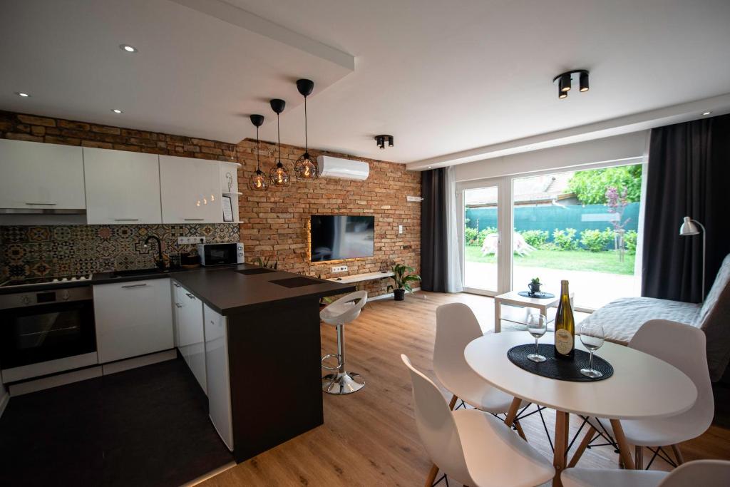 a kitchen and living room with a table and chairs at Pitypang Apartman Kápolnásnyék in Kápolnásnyék