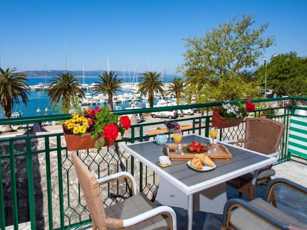 einen Tisch mit einem Teller Essen und Blumen auf dem Balkon in der Unterkunft Lux apartment Mare By the Sea & Beach in Baška Voda