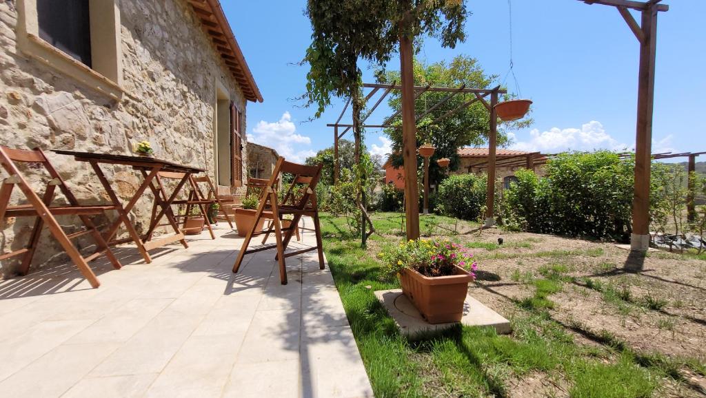 een tuin met stoelen en een tafel en een basketbalring bij Agriturismo Poggio la Lodola in Massa Marittima