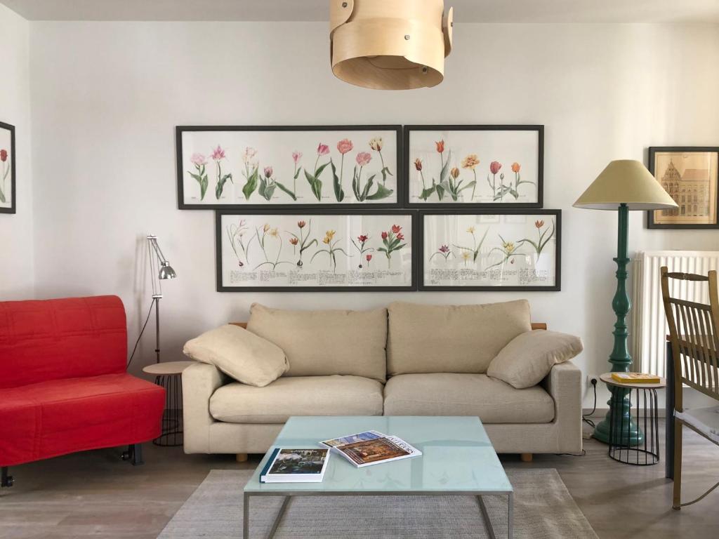 a living room with a couch and a red chair at Giorgio in Antwerp