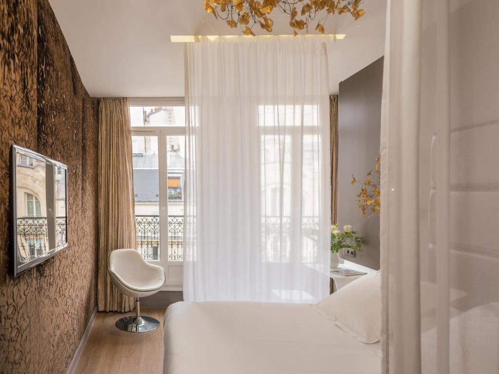 a bedroom with a white bed and a window at Legend Saint Germain by Elegancia in Paris