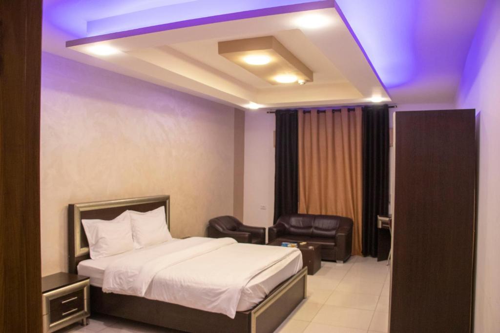 une chambre d'hôtel avec un lit et une chaise dans l'établissement Sara Crown Hotel, à Irbid