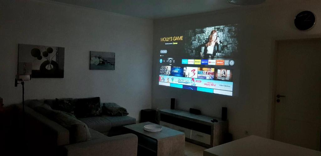 a living room with a couch and a flat screen tv at EasyStay#4 Home Cinema Ferienwohnung in Kliniknähe mit Balkon, Boxspringbett & Netflix in Bad Oeynhausen