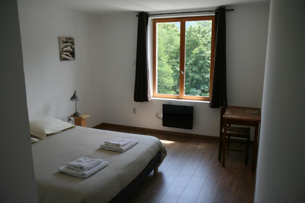 - une chambre avec un lit, une fenêtre et un bureau dans l'établissement Hôtel Restaurant du Pêcheur, à Lavoûte-Chilhac