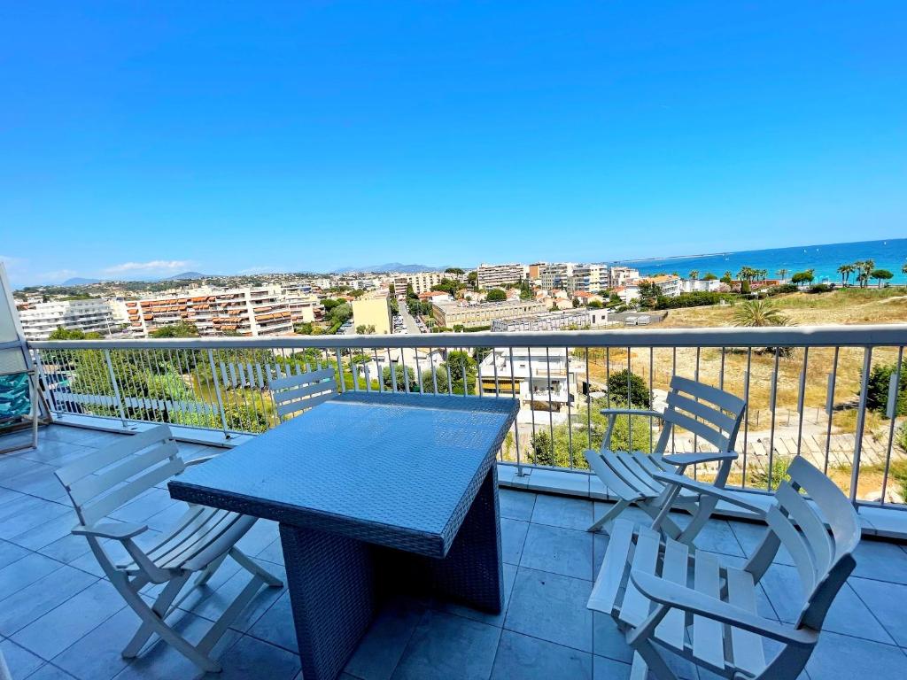 a table and chairs on a balcony with a view of the ocean at Le Chaville in Cagnes-sur-Mer