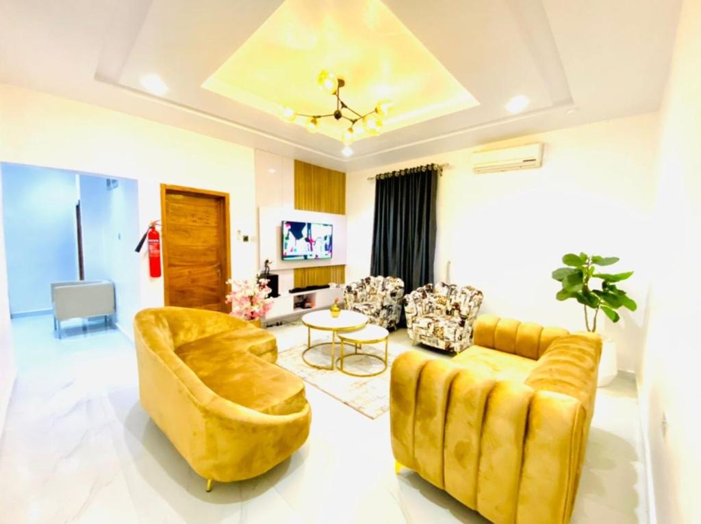 d'un salon avec un canapé et des fauteuils jaunes. dans l'établissement Mr Luxury 3 Bedroom Apartment, à Lagos