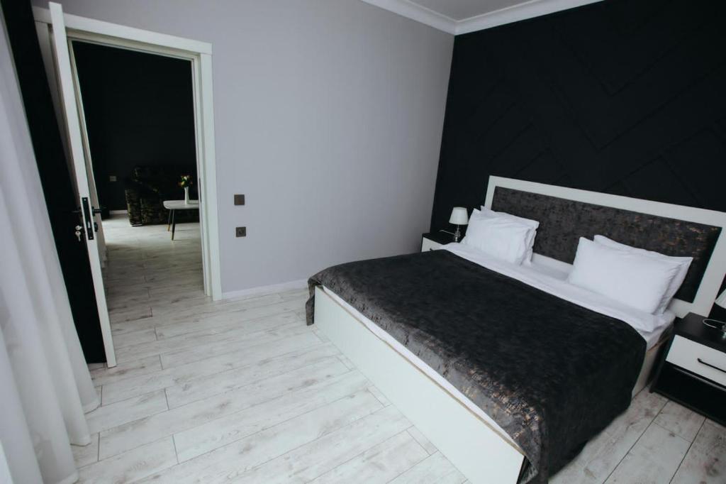 ein Schlafzimmer mit einem großen Bett und einer schwarzen Wand in der Unterkunft Castle Resort Spa Hotel in İsmayıllı