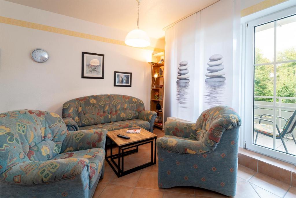uma sala de estar com duas cadeiras e uma mesa em Seepark Wohnung 1 1 em Scharbeutz