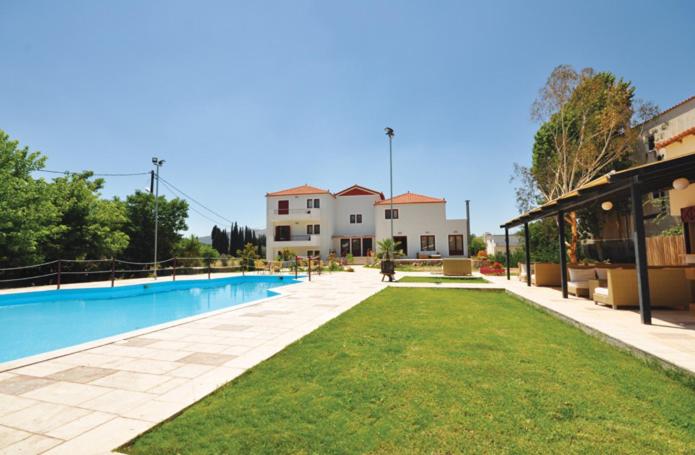 a swimming pool in front of a house with a yard at Actor Hotel in Ligourio