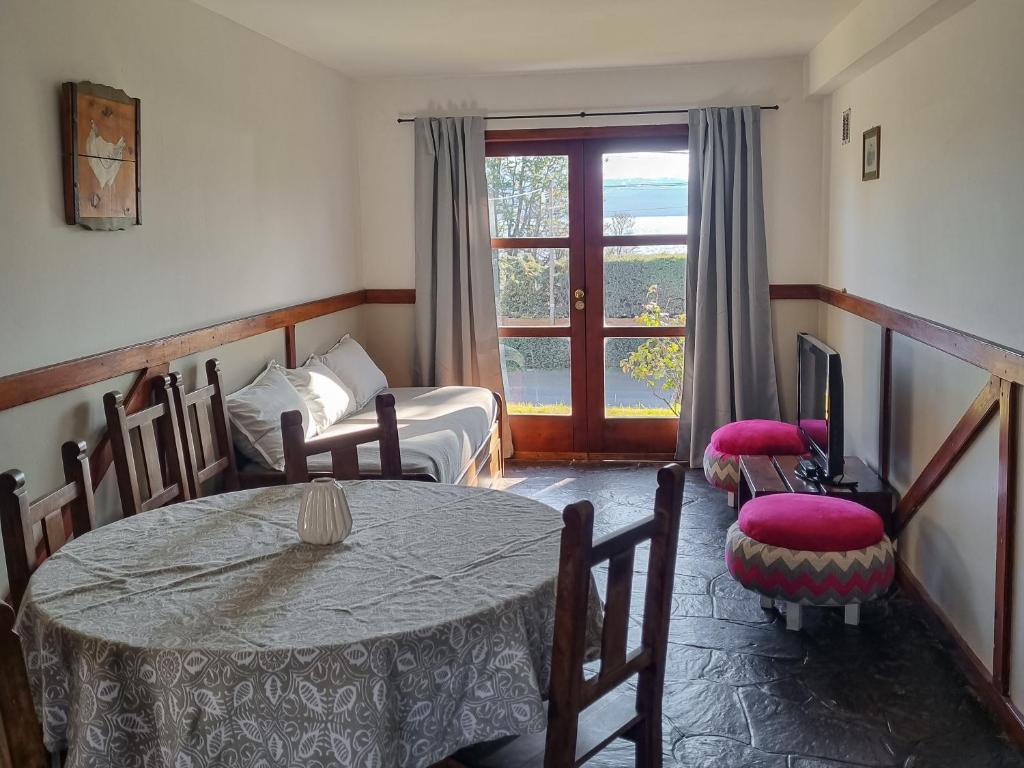 Cette chambre comprend une table, un lit et une fenêtre. dans l'établissement El Cencerro Bariloche, à San Carlos de Bariloche