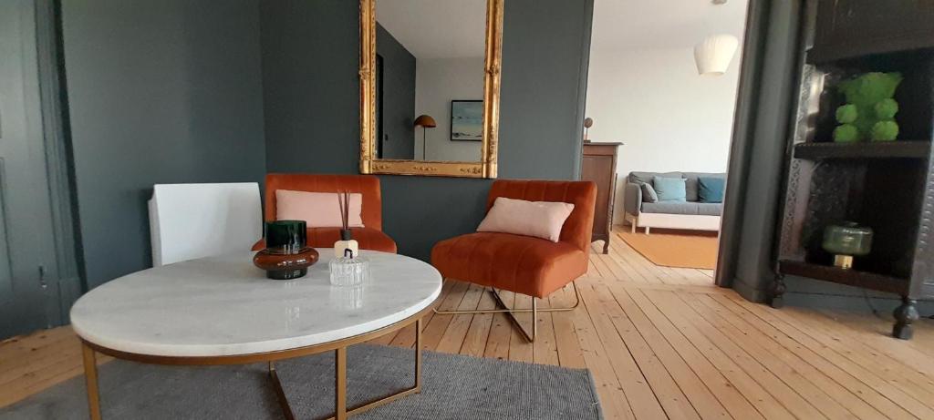 un salon avec une table, une chaise et un miroir dans l'établissement Superbe appartement centre Wimereux, à Wimereux