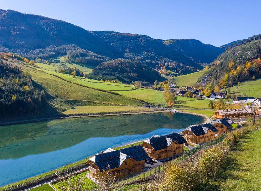 a group of houses on a hill next to a river at CHALET am Schneeberg See in Puchberg am Schneeberg