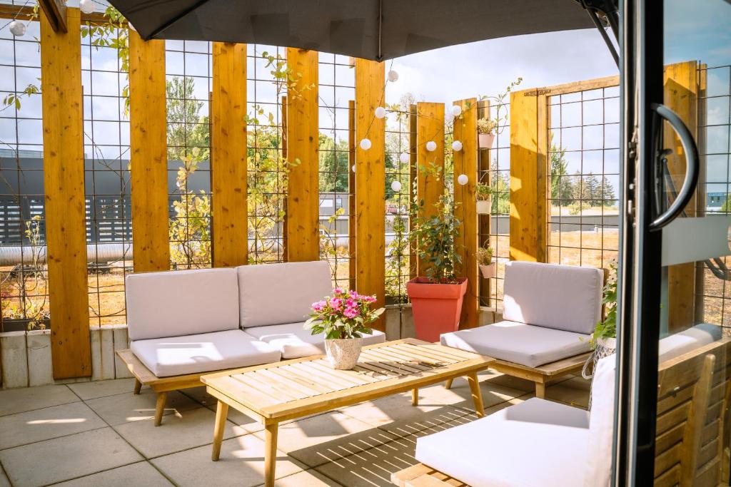 eine Terrasse mit 2 Stühlen, einem Tisch und einem Sonnenschirm in der Unterkunft B&B HOTEL Metz Est Technopole Pôle Santé in Ars-Laquenexy